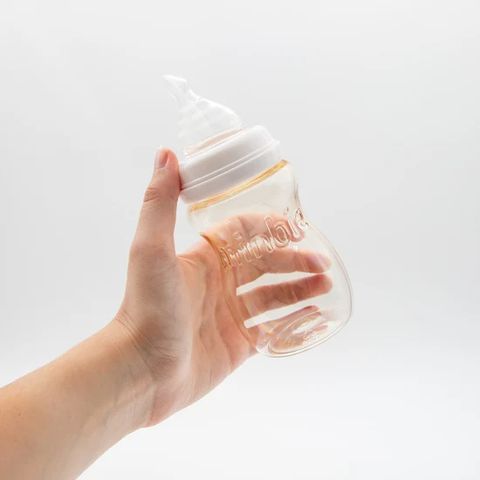 A hand holding a Minbie PPSU bottle