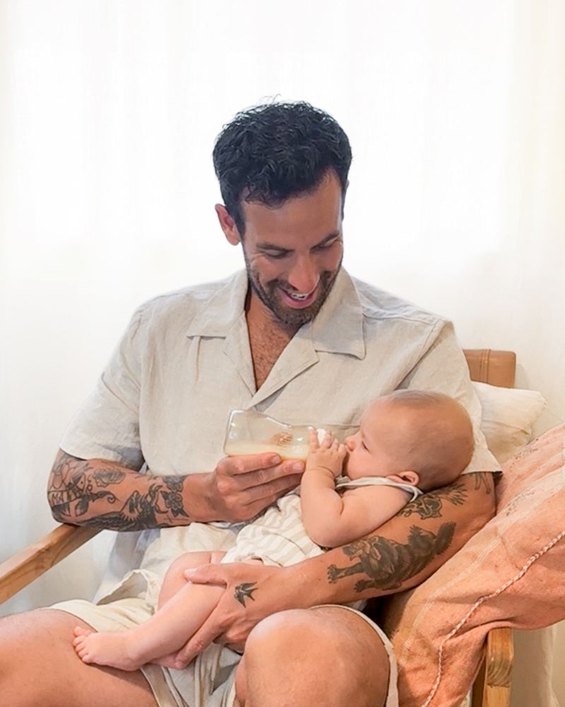 A dad bottle-feeding his baby with a Minbie bottle